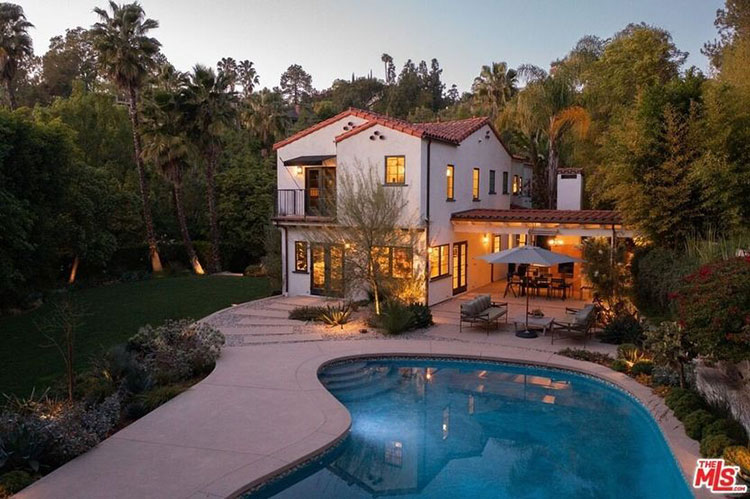 Exterior view of classic Spanish Colonial home with kidney-shaped saltwater pool